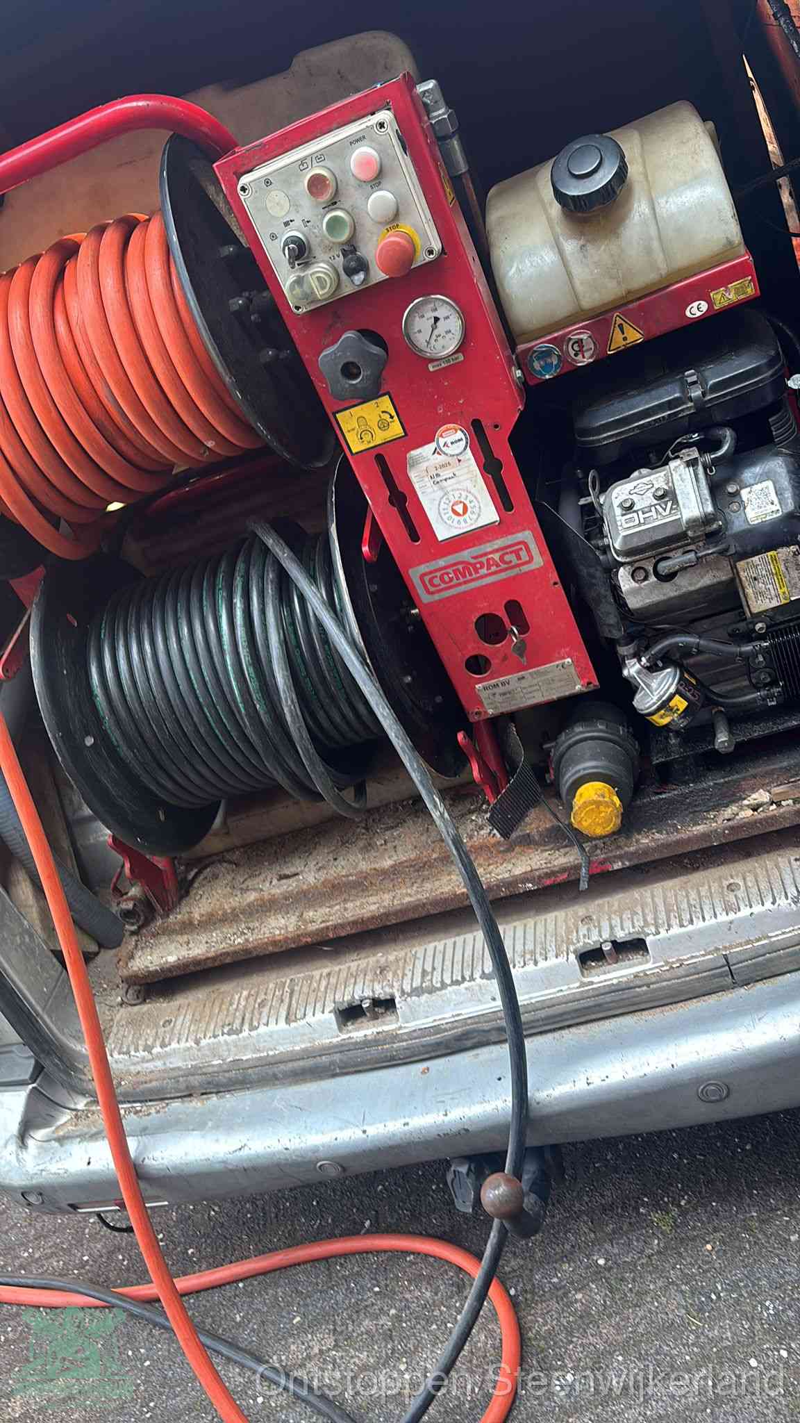 Een rood hogedruk-rioolreinigingstoestel in de laadbak van de bedrijfsbus, apparatuur voor een hardnekkige afvoerverstopping in Steenwijkerland