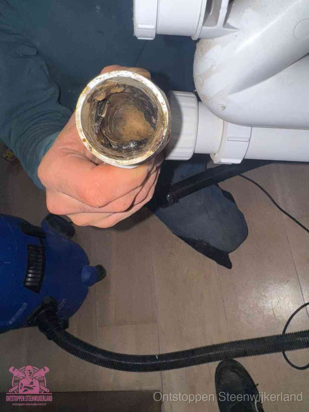 Een losgekoppelde afvoerbuis die van binnen volledig is dichtgeslibd met vet en aanslag, de meest voorkomende oorzaak van een verstopte gootsteen in Steenwijkerland