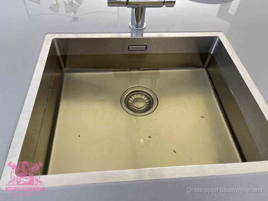 Stilstaand water in een rvs spoelbak dat niet wegloopt, een duidelijk signaal van een gootsteenverstopping in Steenwijkerland